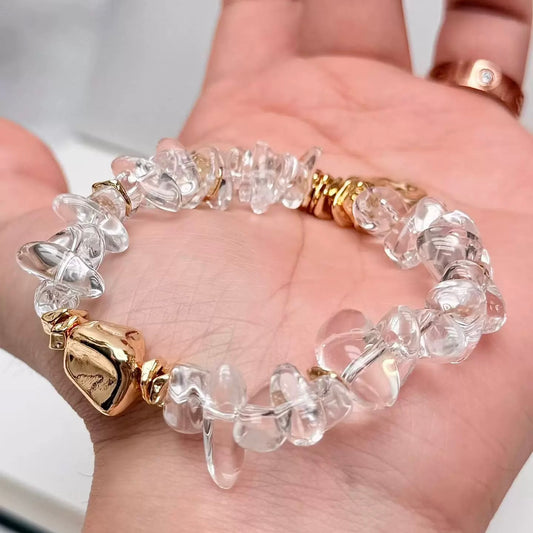 Natural clear quartz beads showing unique organic shapes and shimmering light refraction.
