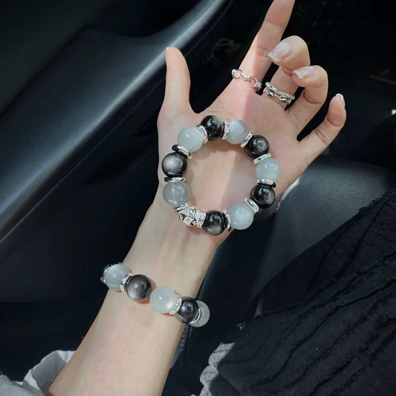 Moonstone and Silver Obsidian bracelet paired with silver-tone accessories and a monochromatic outfit for contemporary jewelry styling.