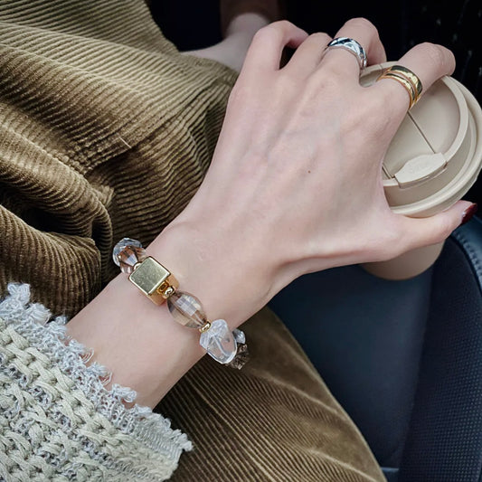 Hand model wearing a Smoky Quartz and Clear Quartz bracelet styled for everyday fashion and modern crystal jewelry collections.