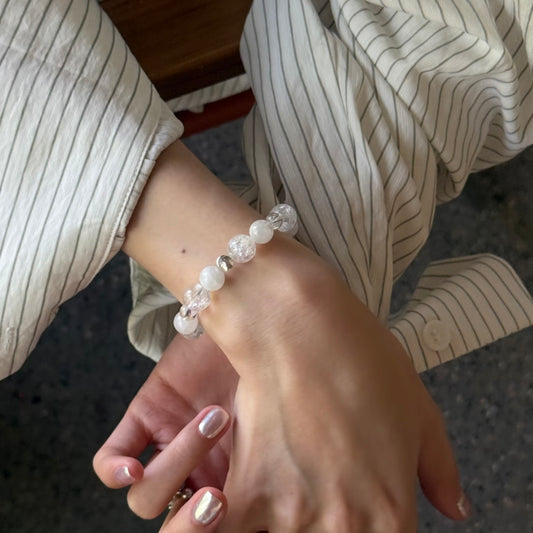 Snowflake white crystal bracelet worn on wrist — 8mm 10mm mixed bead size natural crystal bracelet for minimalist everyday jewellery styling