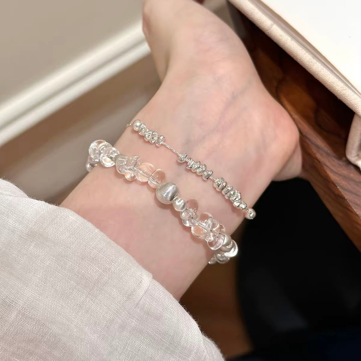 Natural white freeform clear quartz bracelet styled with fine silver jewelry, demonstrating effortless crystal bracelet layering for everyday wear.