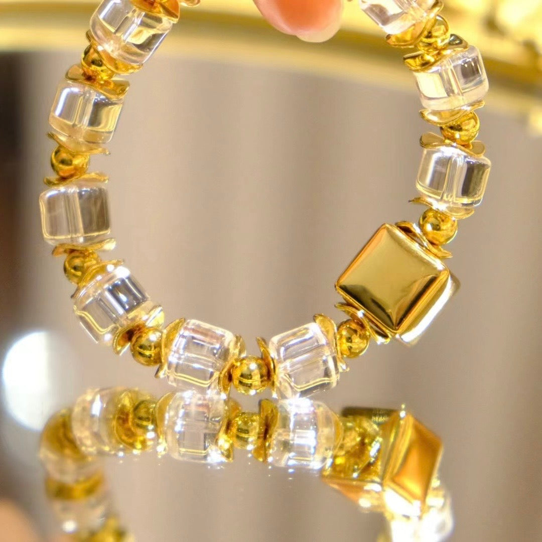 Model stacking the geometric wheel bead bracelet with a sleek gold cuff for a modern look.