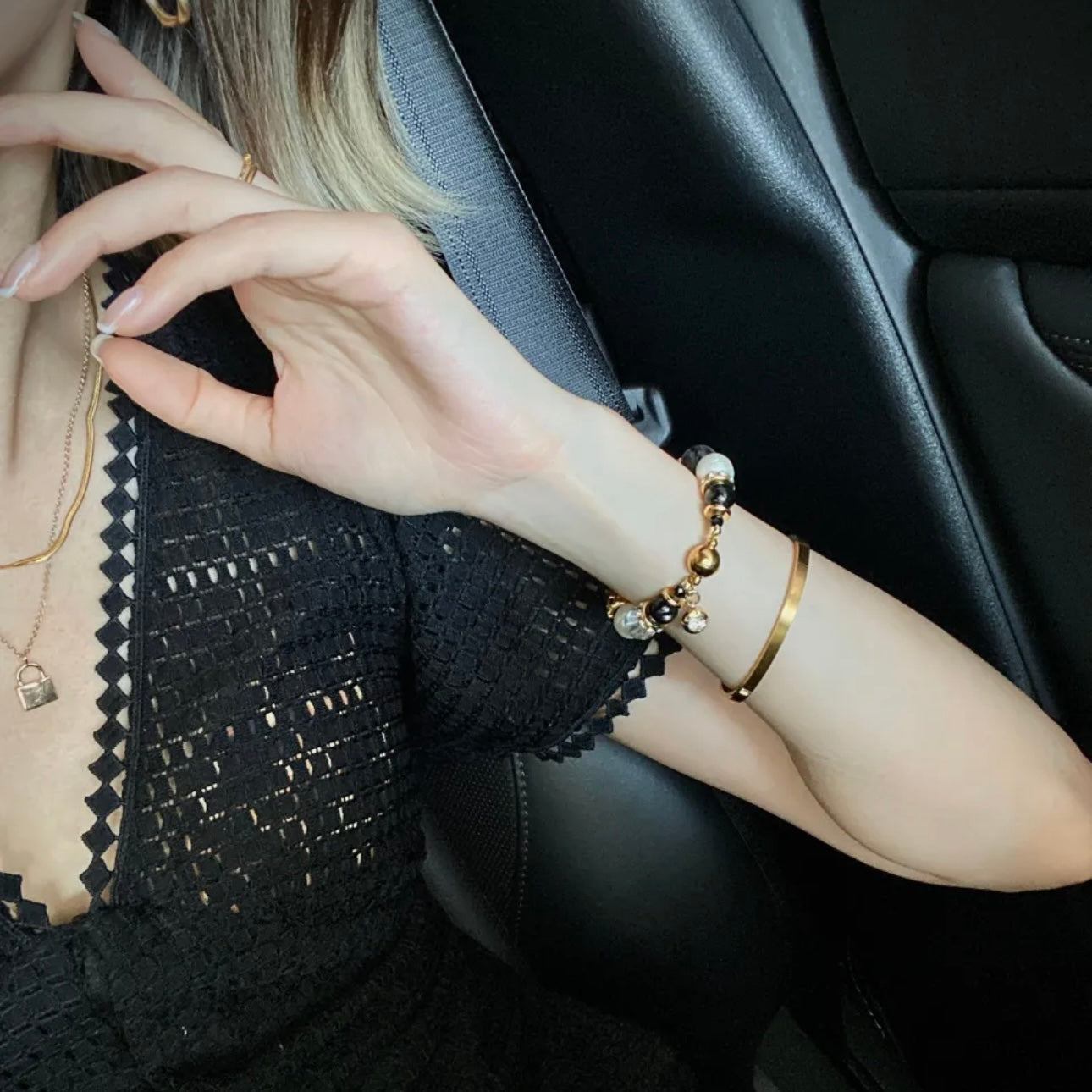 Side angle of Starlight Freshwater Pearl and Aura Quartz bracelet on model, gold shimmer hardware catching light, minimalist luxury wrist stack