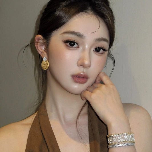 Model wearing the 26mm wide Muse Medallion earrings, showcasing the bold statement scale and artistic fit.