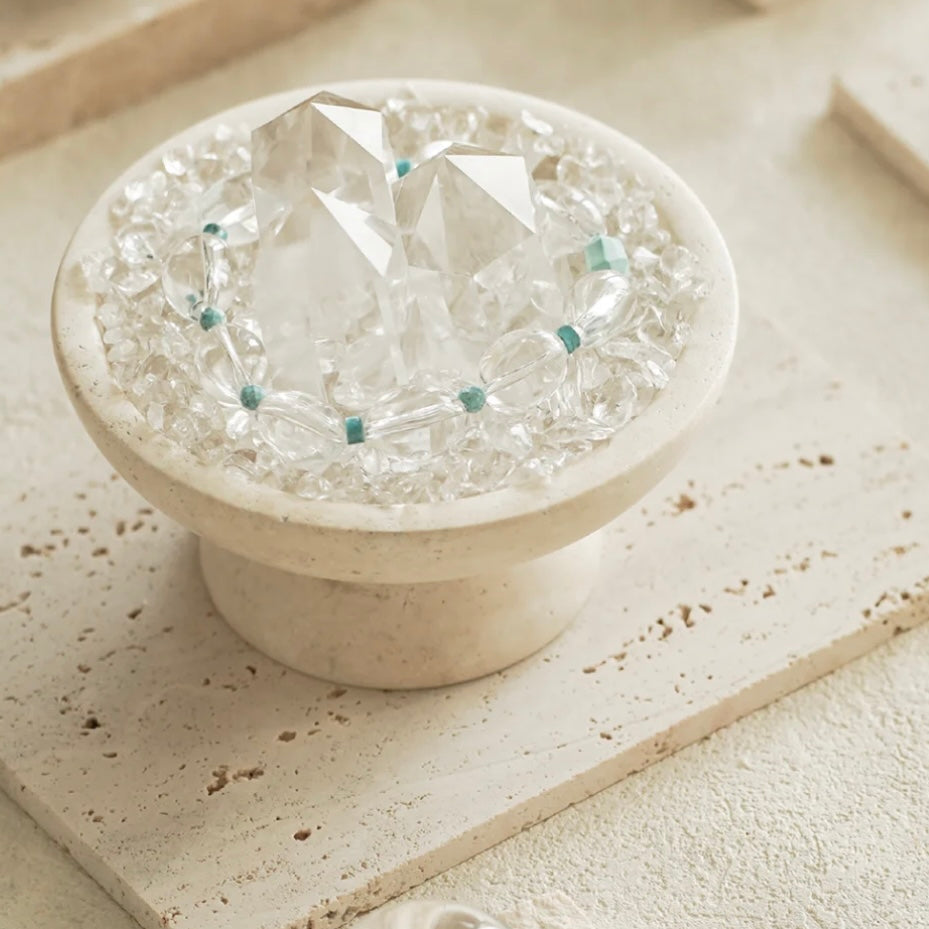 Top-down view of 3 clear quartz points and chips paved inside the energy vessel.