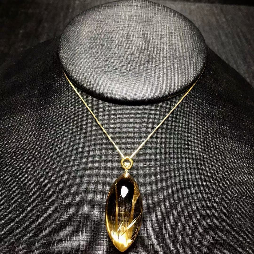 The exact 1 of 1 18K gold marquise cut titanium rutilated quartz pendant with unique solar flare rutiles.