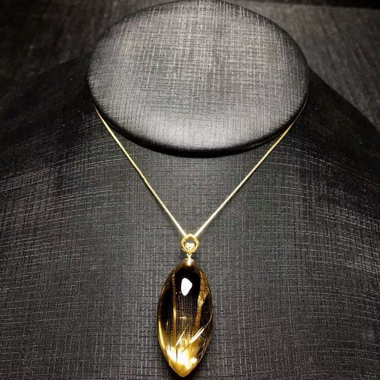The exact 1 of 1 18K gold marquise cut titanium rutilated quartz pendant with unique solar flare rutiles.