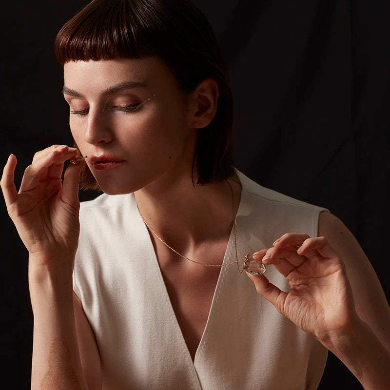 A lifestyle shot of a model wearing the crystal vial pendant, illustrating its sophisticated modern Victorian style.