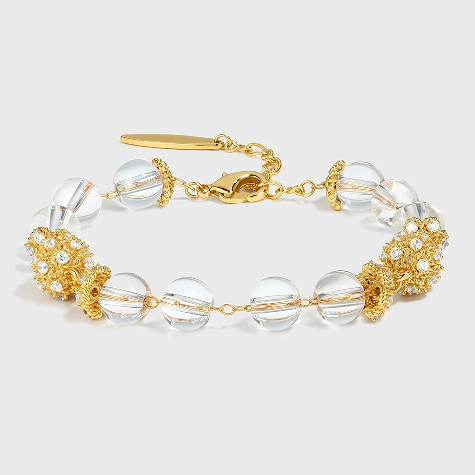 A close-up of the clear quartz and shell pearl bracelets from the set.