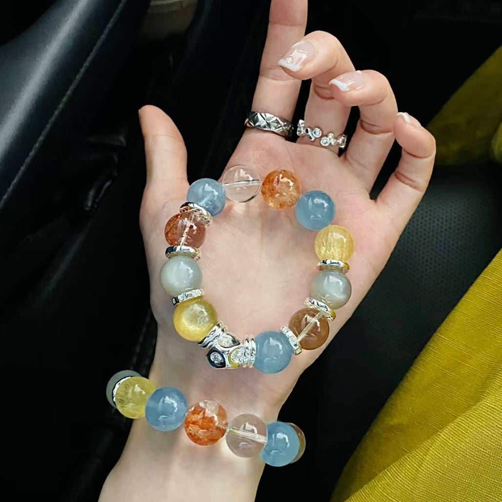 Woman wearing vibrant candy-colored 15mm crystal bracelet on wrist, featuring aquamarine and citrine beads, beach party summer jewelry
