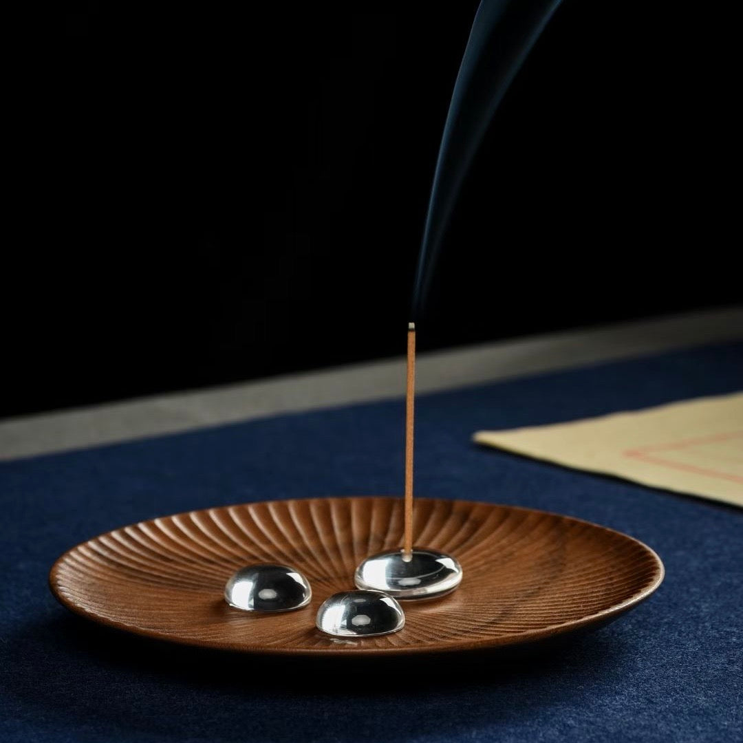 Natural white crystal incense holder in a dewdrop shape with rising smoke.