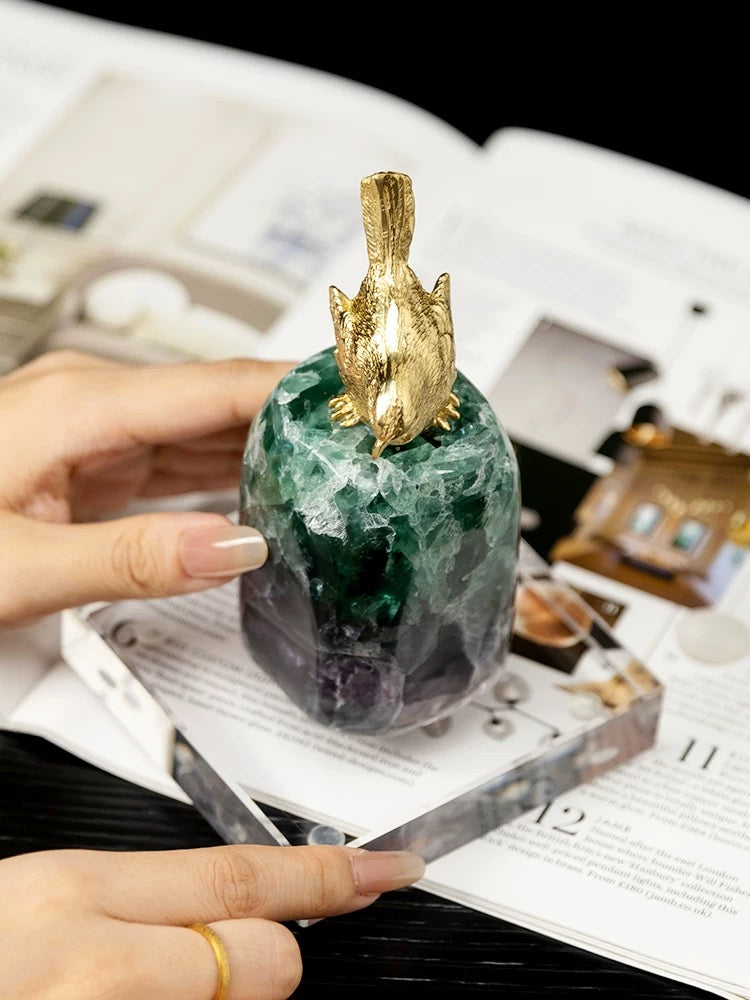 Handheld view of the brass fortune bird on green fluorite with a square K9 crystal base, architectural home decor.